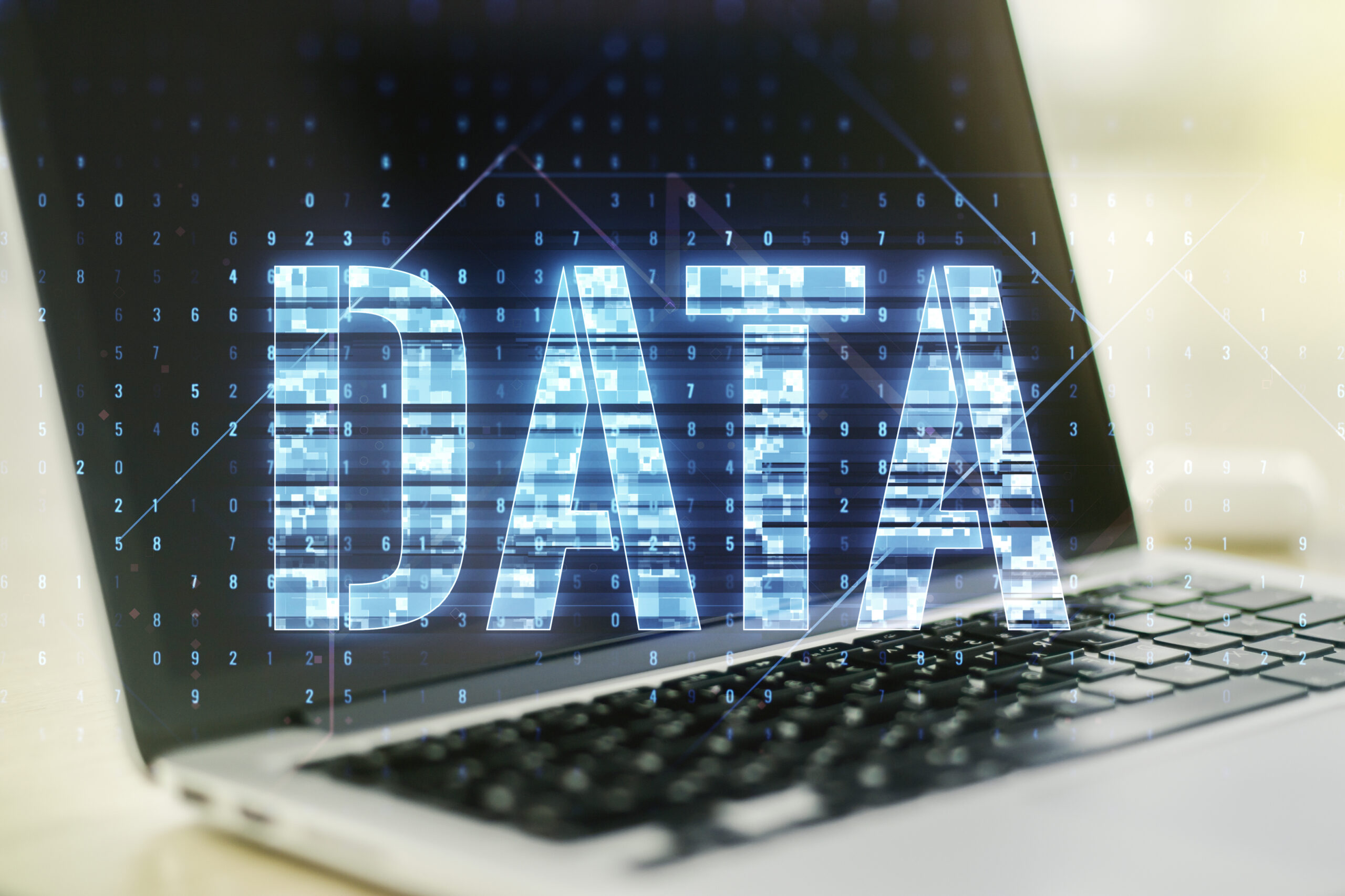 Close-up view of a laptop screen displaying digital "DATA" visualization with cascading numbers and interconnected nodes.
