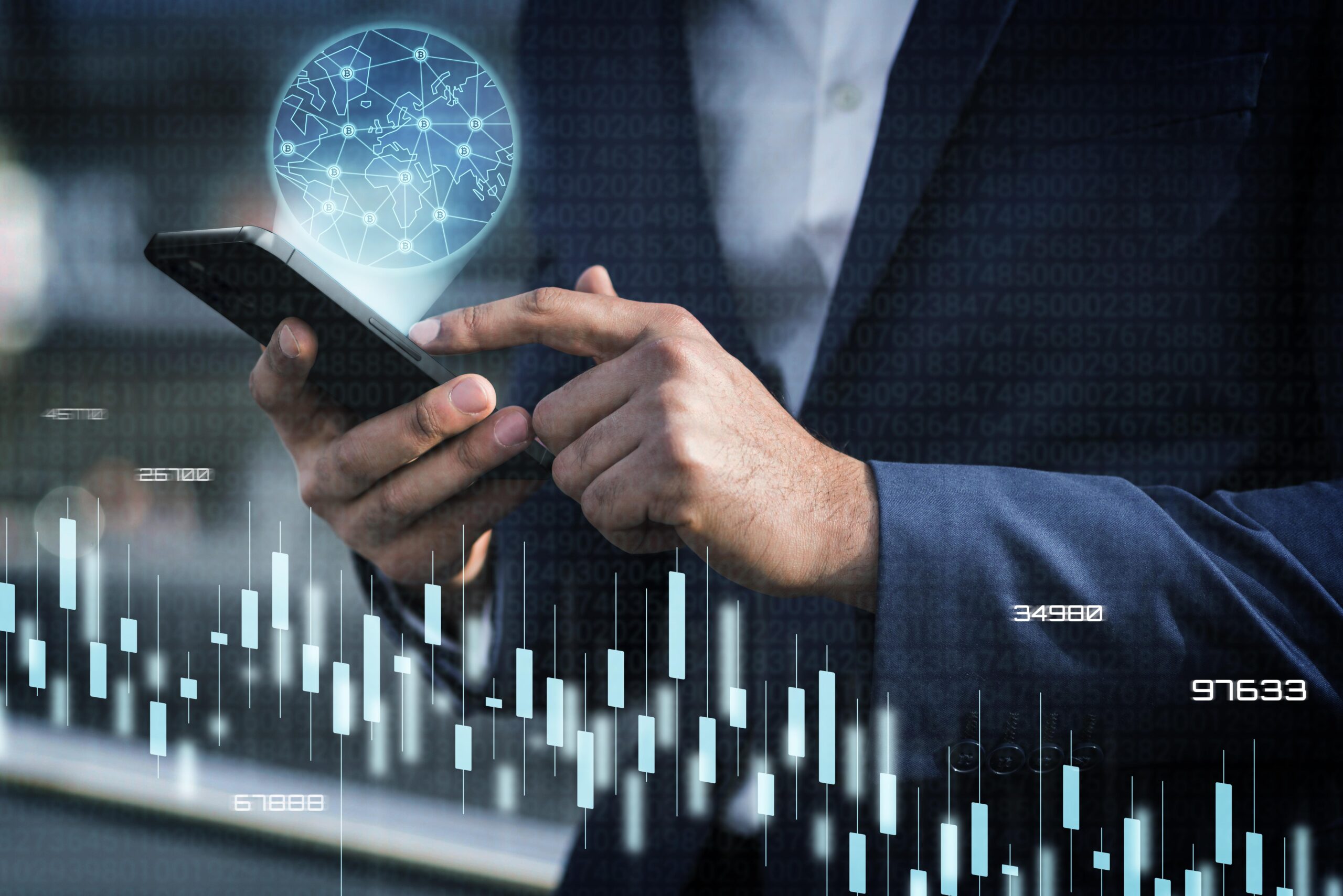 A business professional in a suit uses a smartphone with a holographic image of a global network and financial charts overlayed, symbolizing the integration of technology and finance.